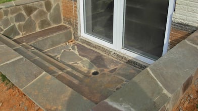 stone steps leading to basement egress window